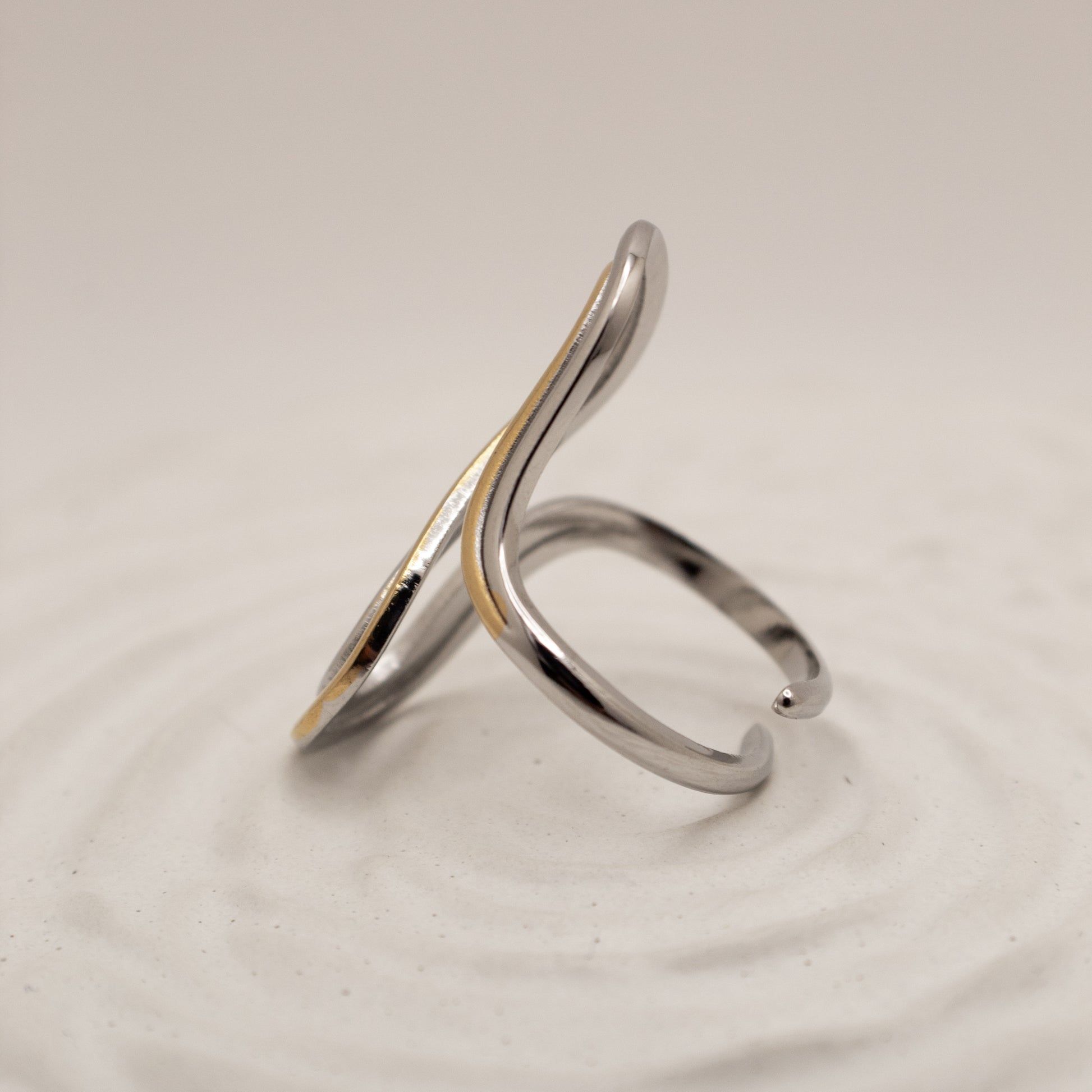Silver ring with a gold accent on a light gray background