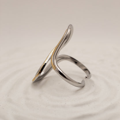 Silver ring with a gold accent on a light gray background