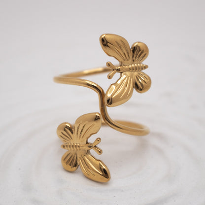 Gold butterfly-shaped ring on a white background