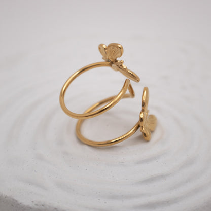 Gold ring and earring set on a textured white surface