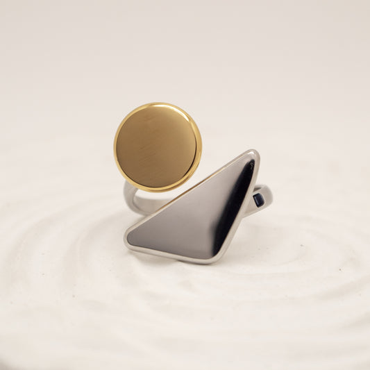 Gold and silver ring on a light beige background