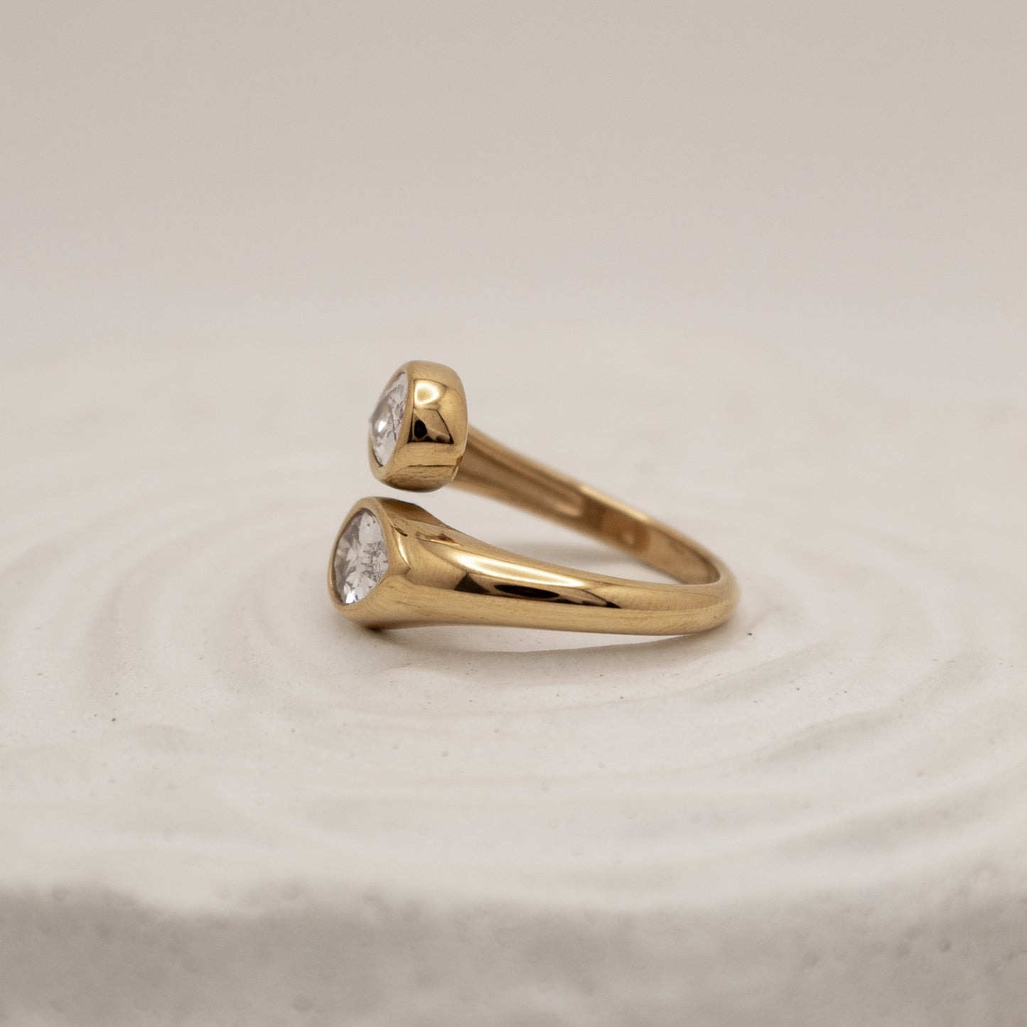 Gold ring with diamond stones on a beige background