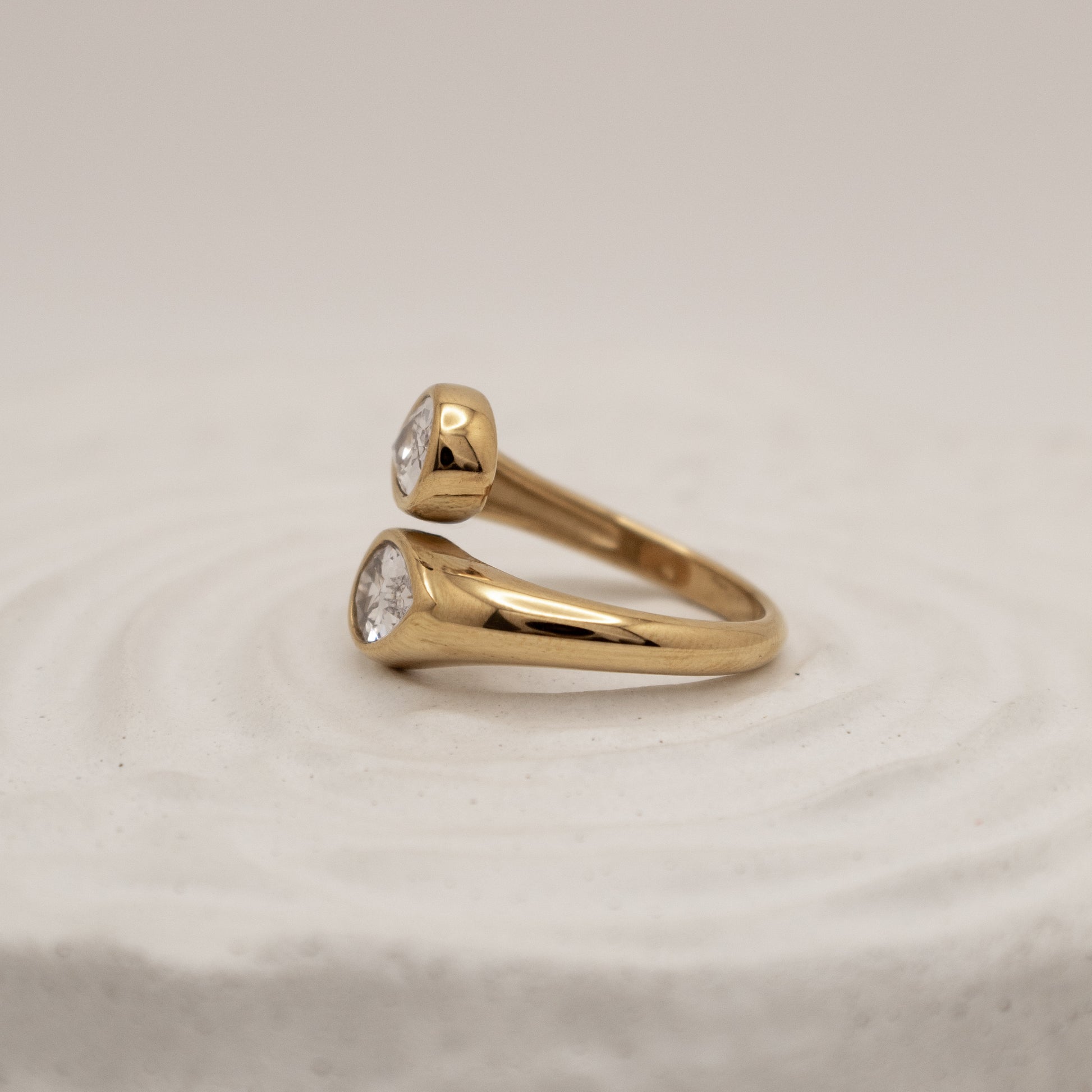 Gold ring with diamond stones on a beige background