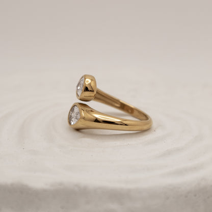 Gold ring with diamond stones on a beige background