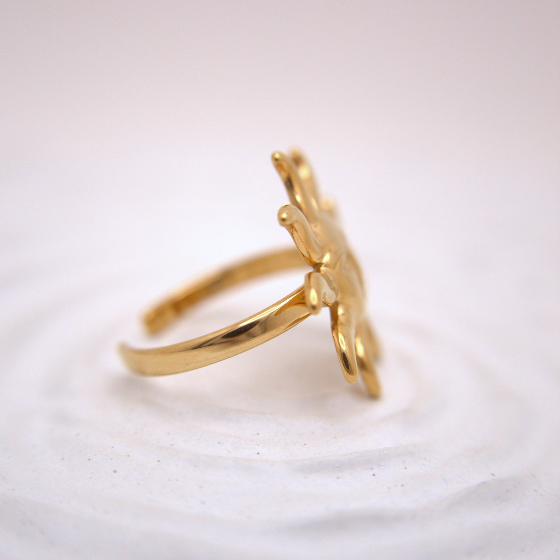 Gold ring with a unique design on a light background