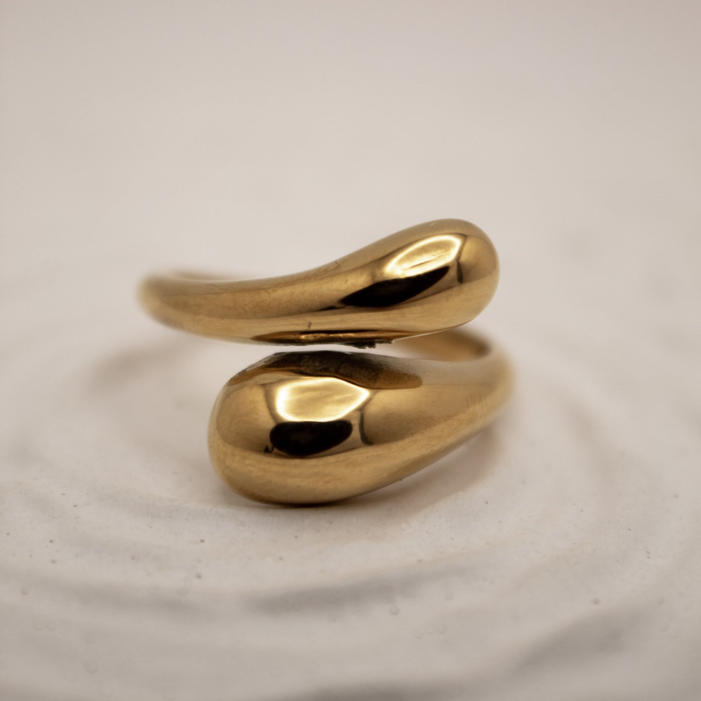 Gold ring with a unique design on a light gray background