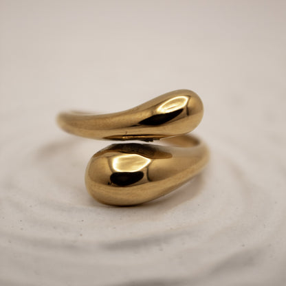 Gold ring with a unique design on a light gray background