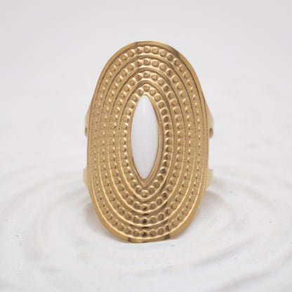 Gold ring with intricate design on a white background