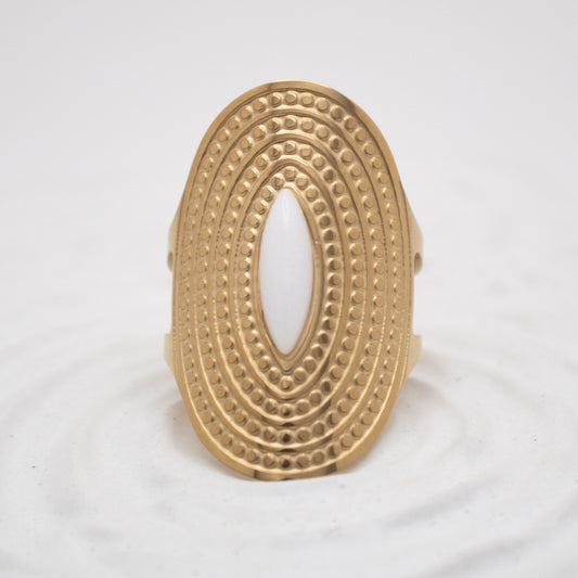 Gold ring with intricate design on a white background