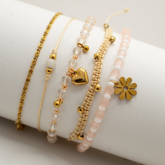 Set of gold and beaded bracelets on a white surface