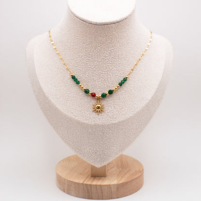 Necklace with green and red beads on a mannequin bust with a white background