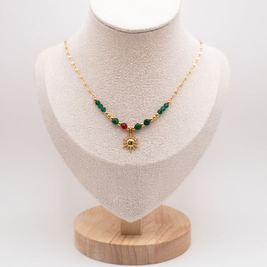 Necklace with green and red beads on a mannequin bust with a white background