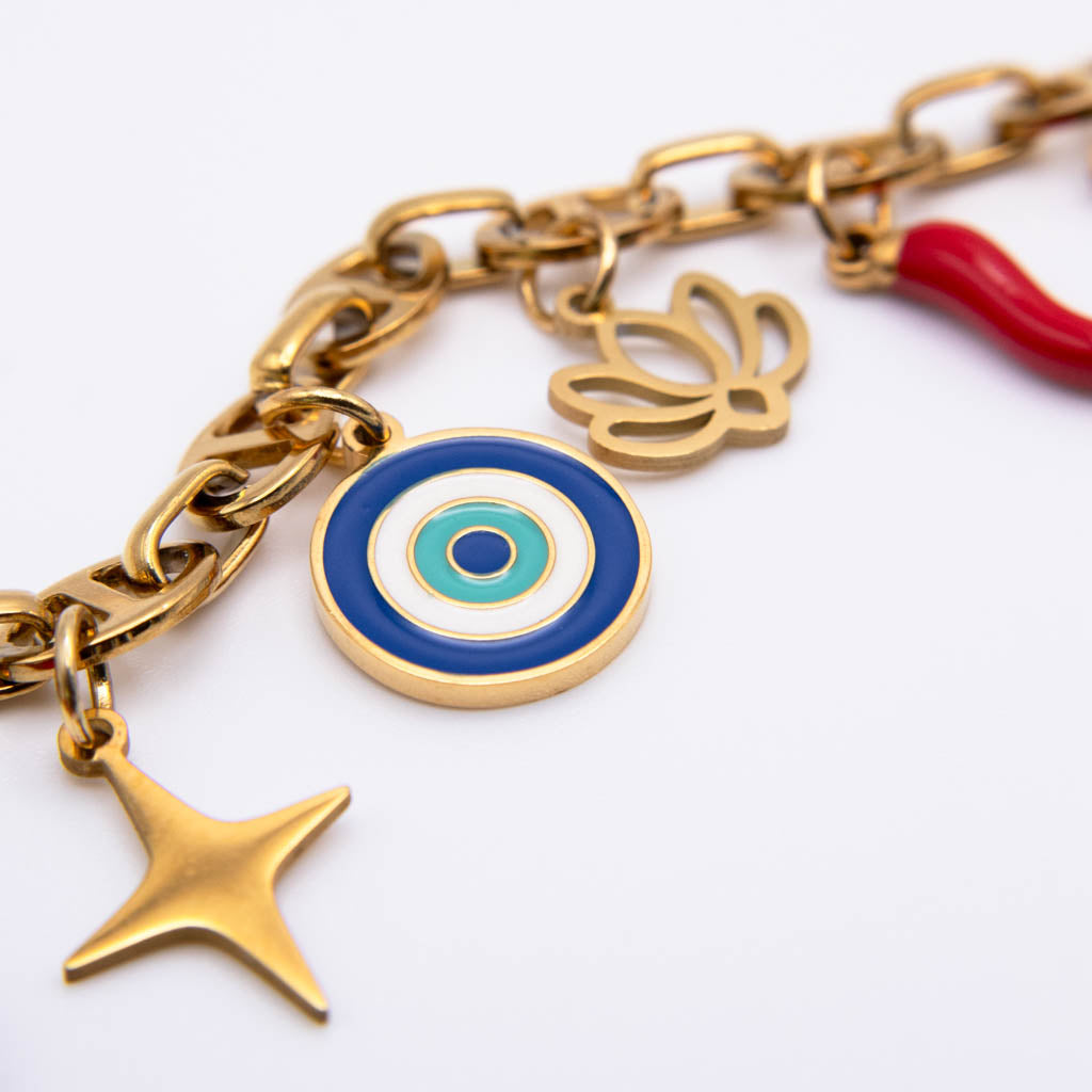 Gold-tone charm bracelet featuring a blue, green, and white evil eye target charm, a gold star charm, a gold flower charm, and a red accent charm, shown on a white background.
