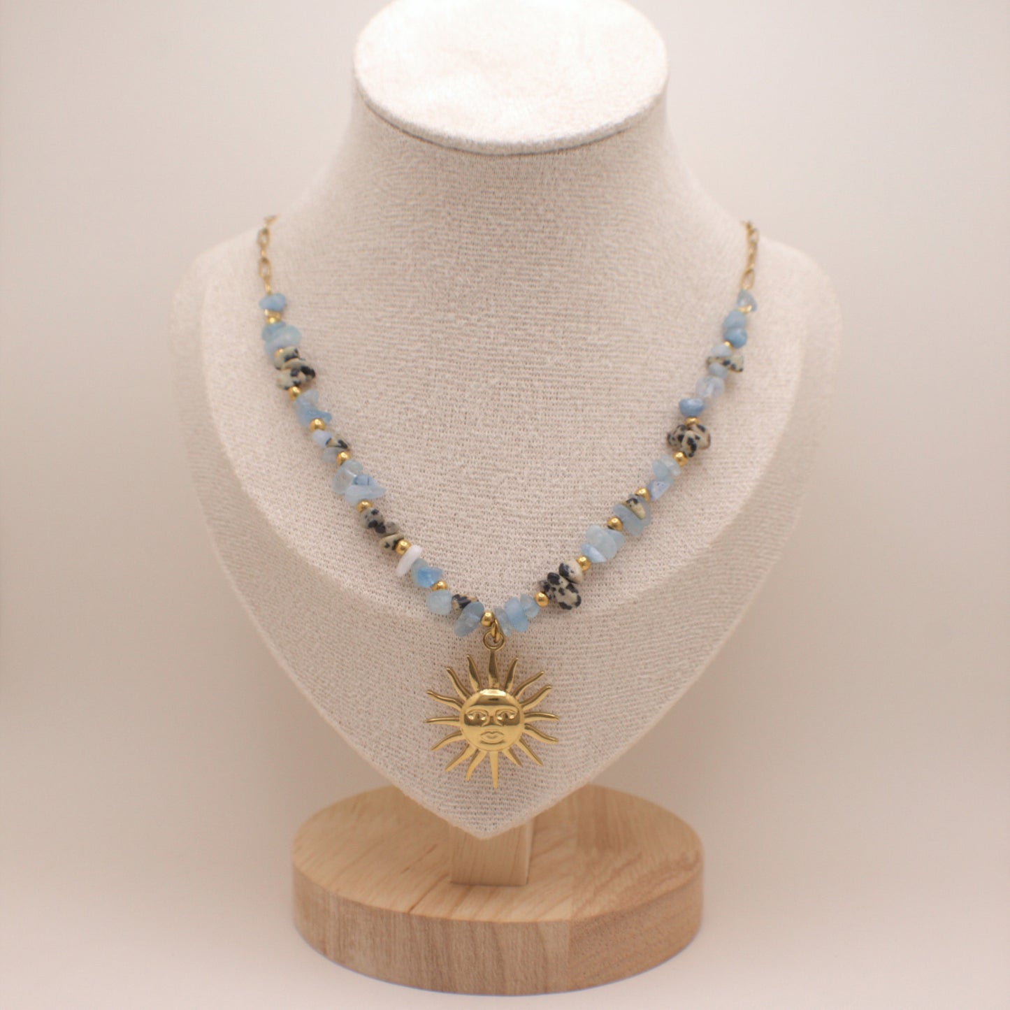 Necklace with a sun pendant on a mannequin bust against a white background