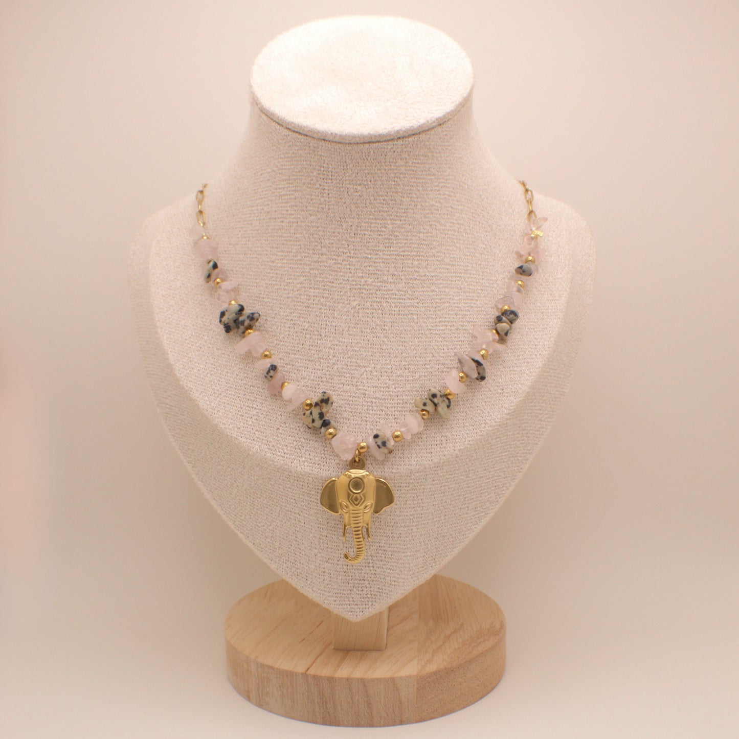 Necklace with an elephant pendant on a mannequin bust against a plain background