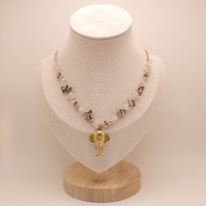 Necklace with an elephant pendant on a mannequin bust against a plain background