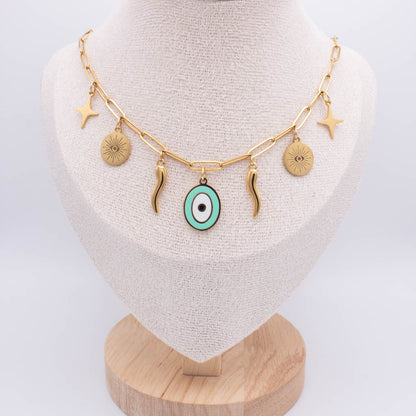 Gold chain necklace with multiple charms, including a central turquoise and white evil eye pendant, displayed on a beige fabric jewelry bust.