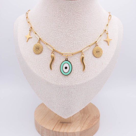 Gold chain necklace with multiple charms, including a central turquoise and white evil eye pendant, displayed on a beige fabric jewelry bust.
