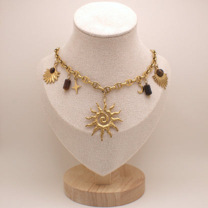 Gold necklace with sun pendant on a mannequin bust against a white background