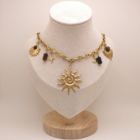 Gold necklace with sun pendant on a mannequin bust against a white background