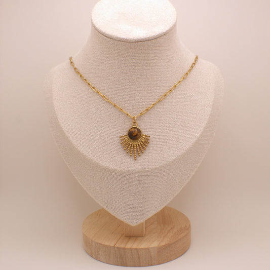 Gold necklace with a pendant on a mannequin bust against a plain background