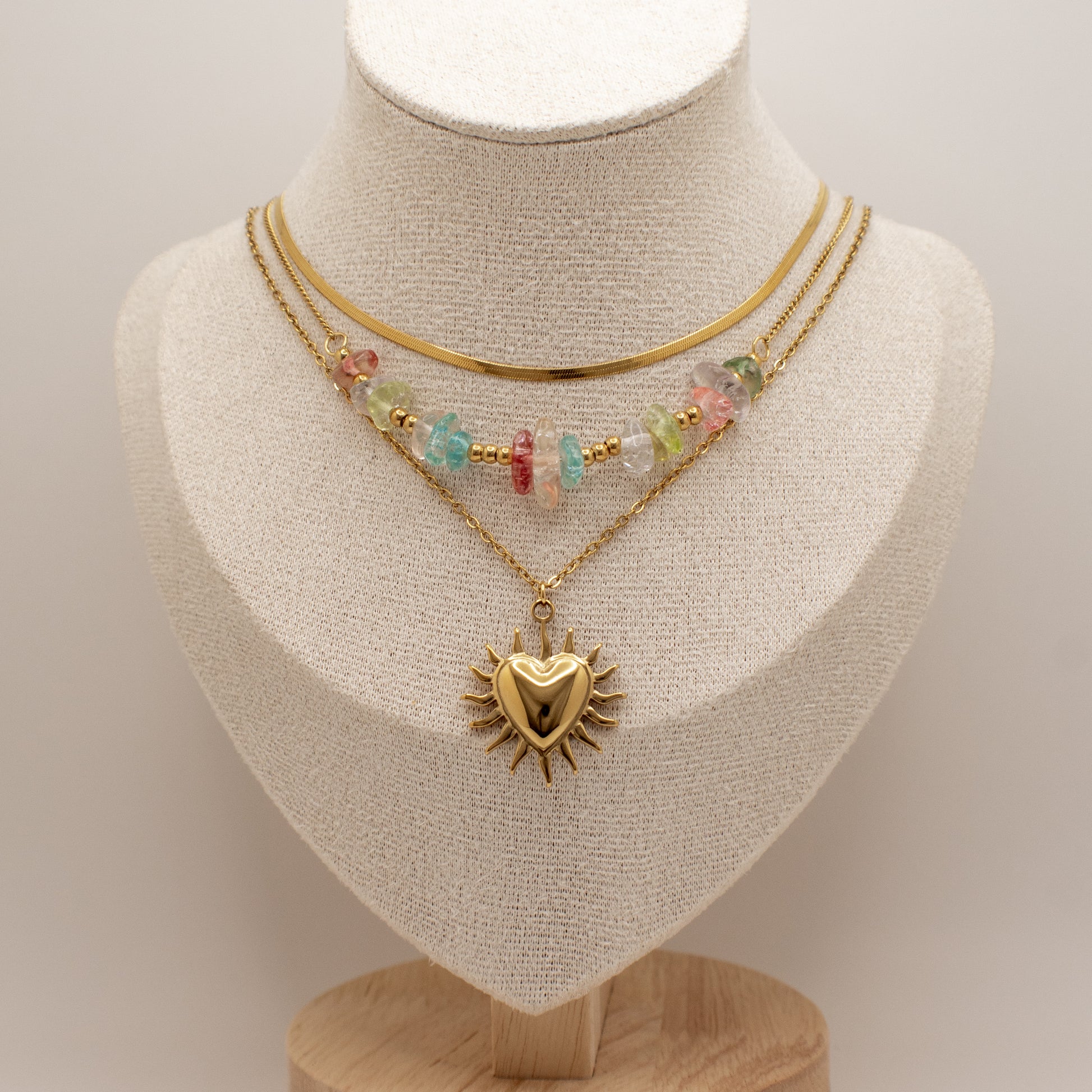 Two necklaces on a mannequin bust with a plain background