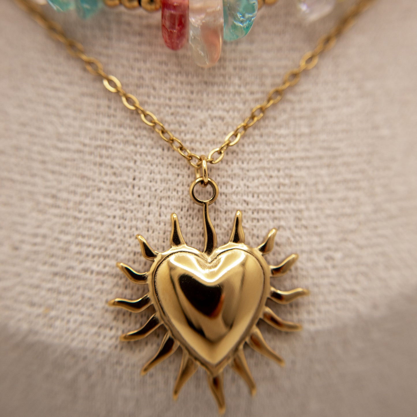 Gold heart-shaped pendant necklace on a neutral background