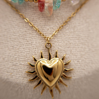 Gold heart-shaped pendant necklace on a neutral background