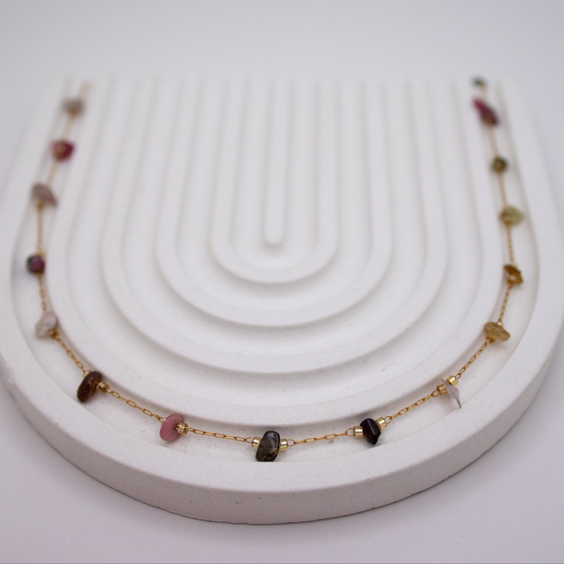 Necklace with gemstones on a white stand