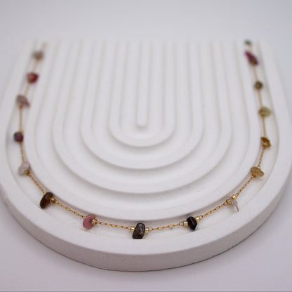Necklace with gemstones on a white stand