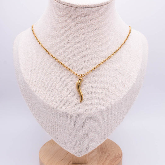 A gold chain necklace with a small curved pendant displayed on a cream fabric jewelry bust against a light gray background.