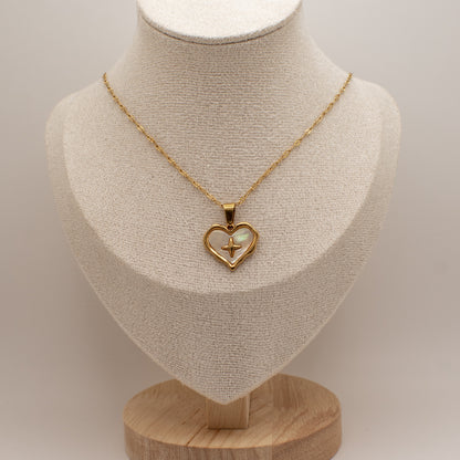 Gold necklace with a heart-shaped pendant on a mannequin bust.