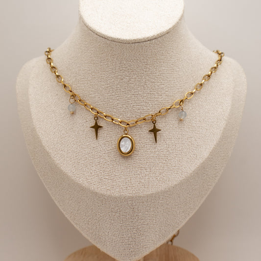 Gold necklace with star and oval pendant on a mannequin bust.