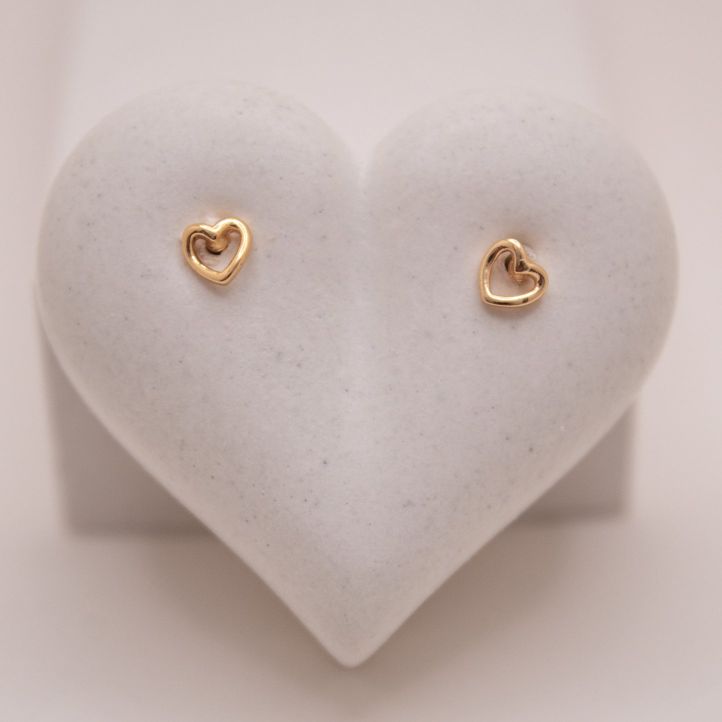 Gold heart stud earrings with high-shine finish by Selva&Co.