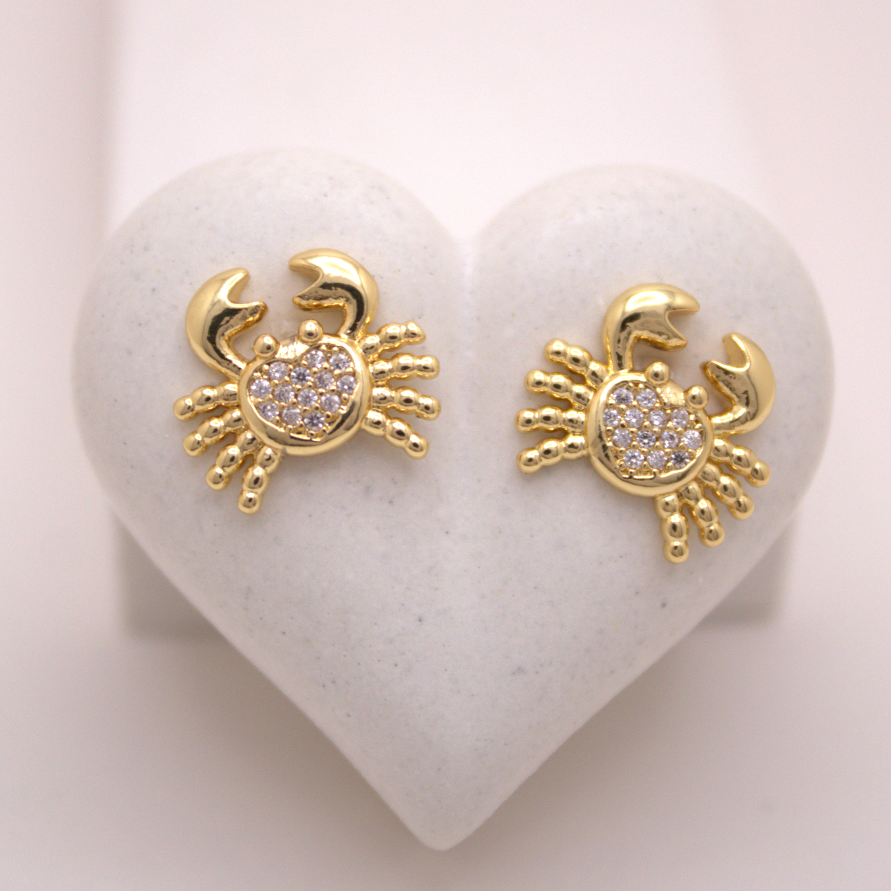 Gold crab-shaped stud earrings with white zirconia pavé center by Selva&Co.