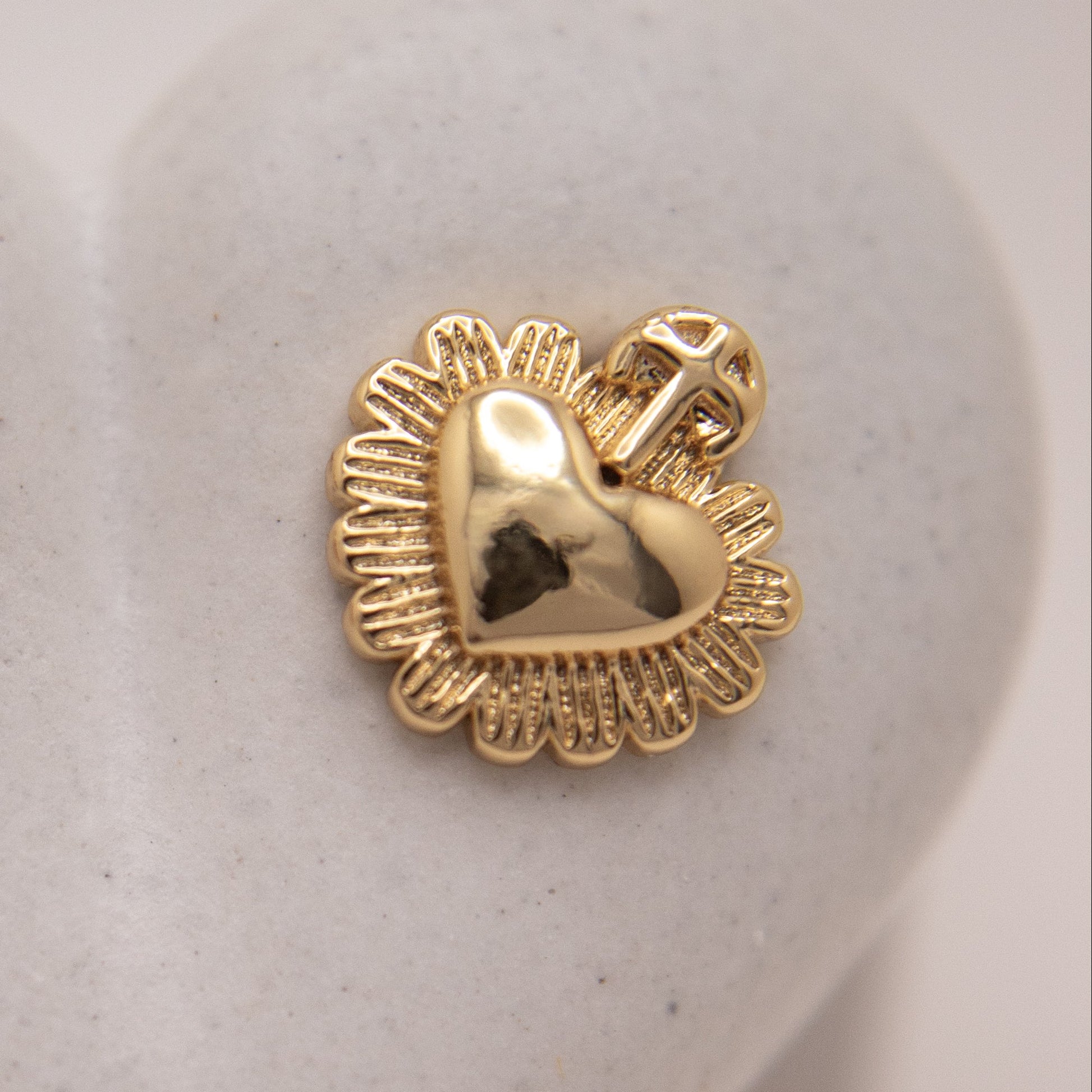 Faith-inspired gold stud earrings with heart and cross design.