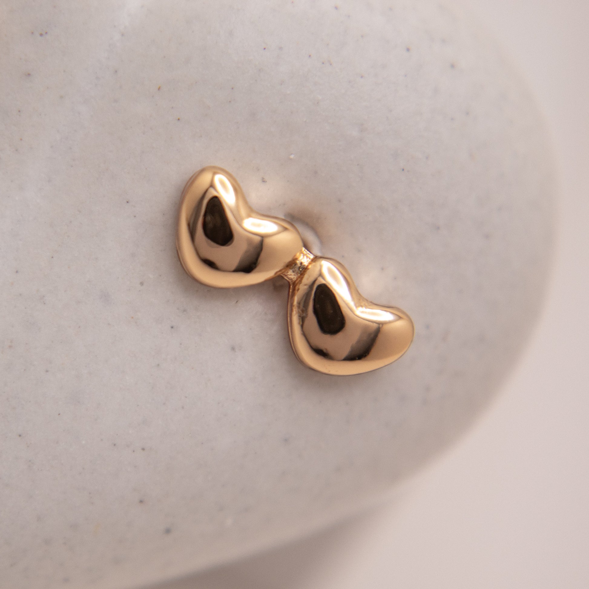 Romantic double heart stud earrings in gold rose finish.