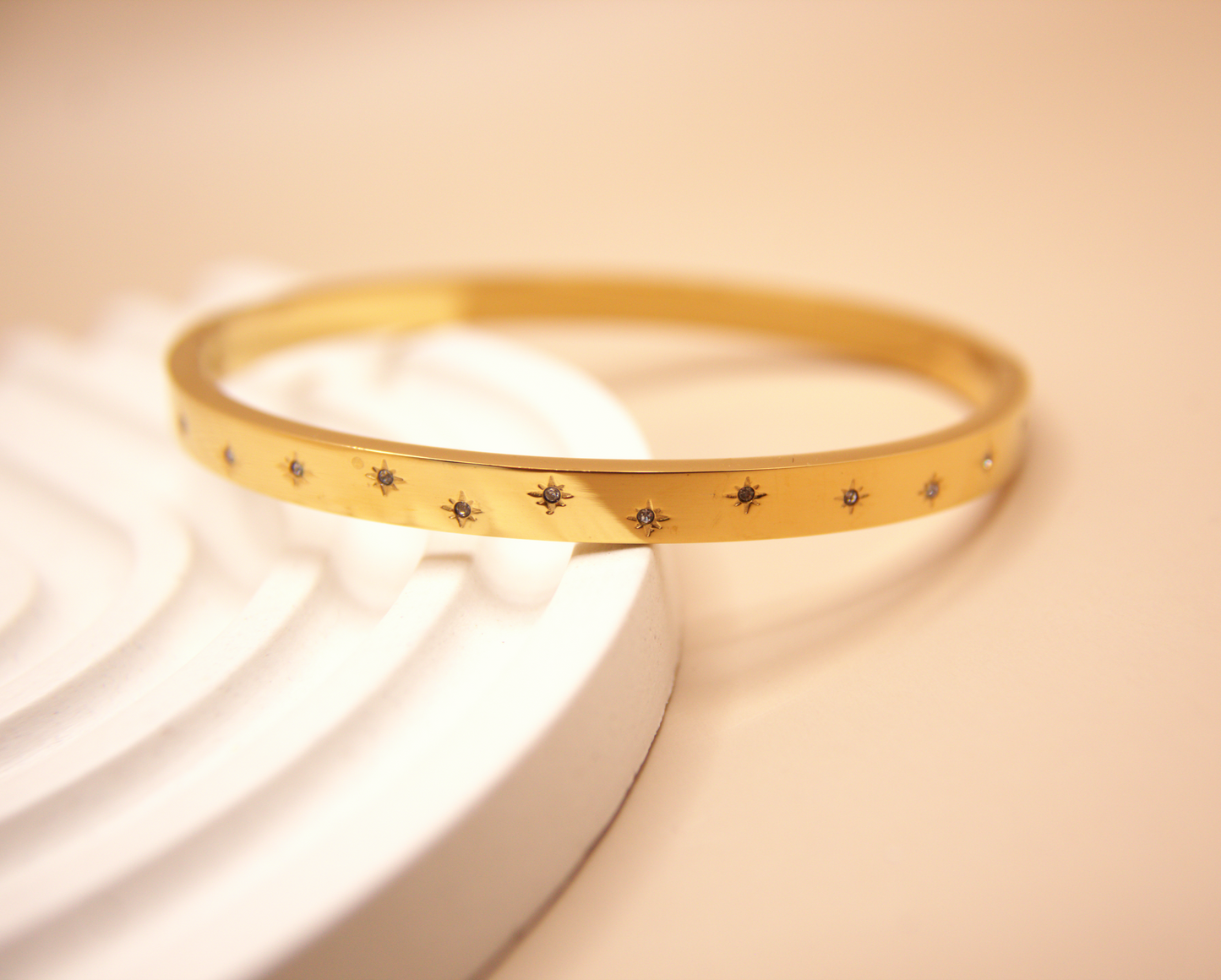 Gold bangle bracelet with engraved star details, PVD stainless steel.