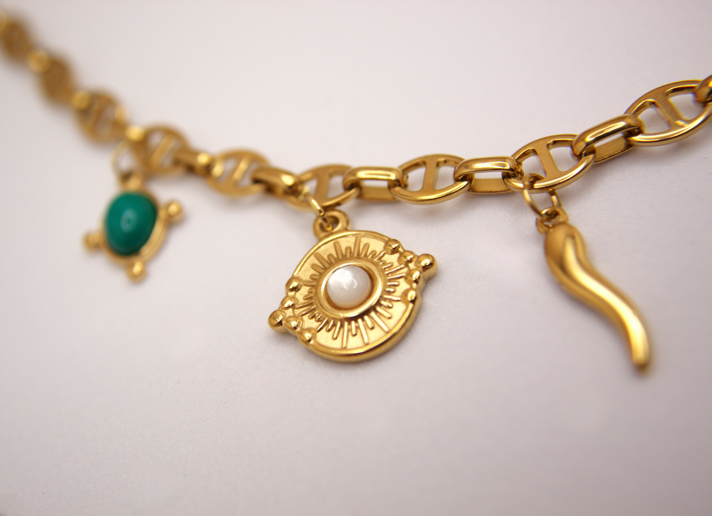 Statement gold charm necklace with amulet details, hypoallergenic PVD stainless steel.