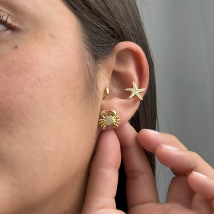 Small golden crab earrings with shimmering stones and rhodium-plated finish.