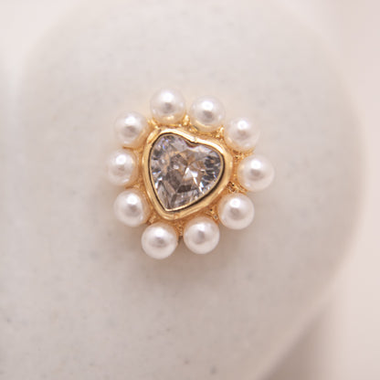 Heart-shaped gold studs featuring clear crystal and pearl details.