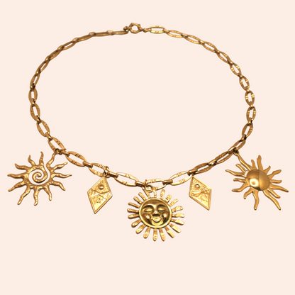 Gold multi-charm necklace with sun-inspired pendants, PVD stainless steel link chain.