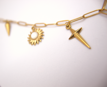 Trendy multicharm necklace with bold gold pendants and link chain.