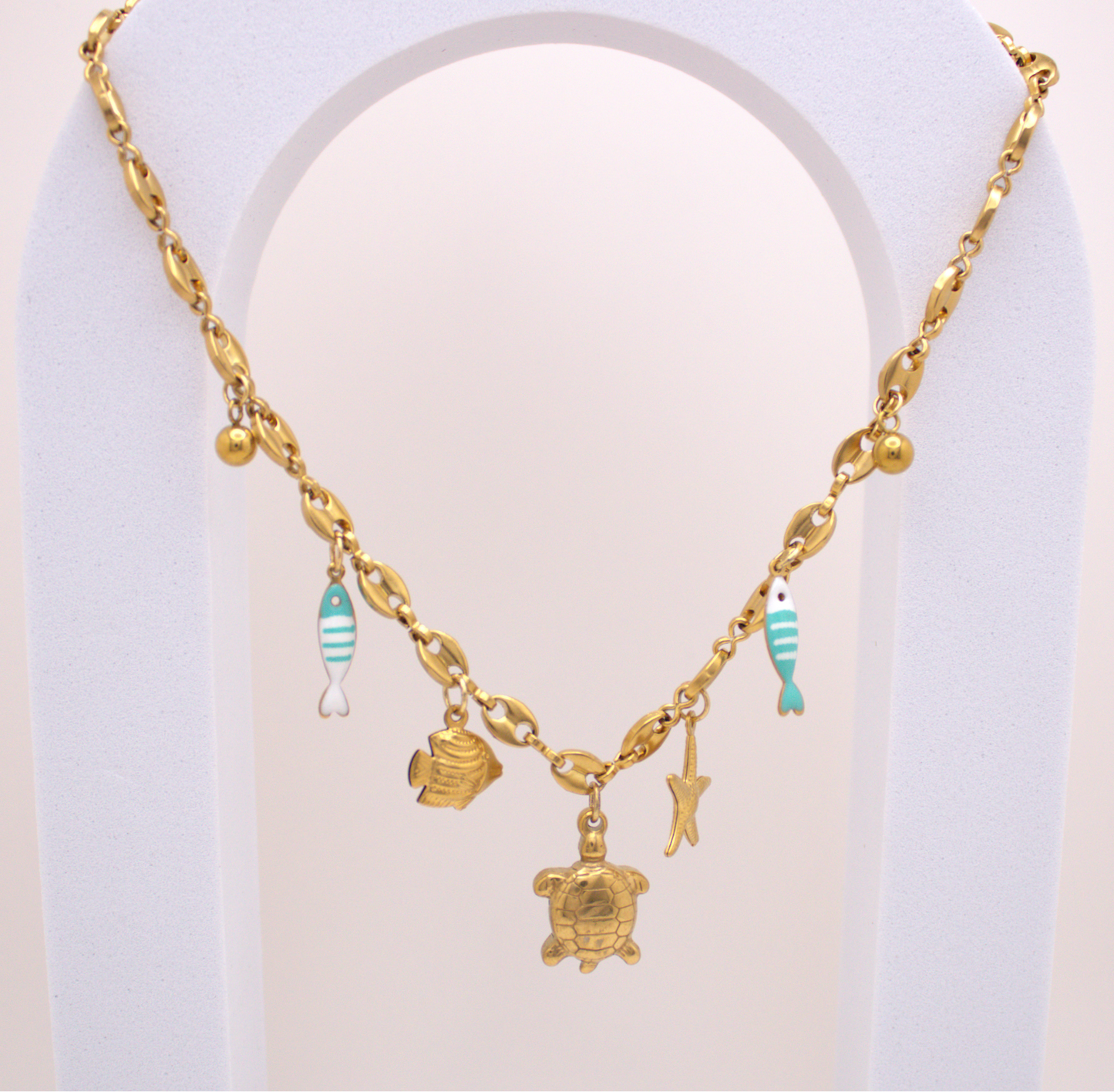 Ocean Breeze Necklace in gold with turtle, starfish, and turquoise fish charms