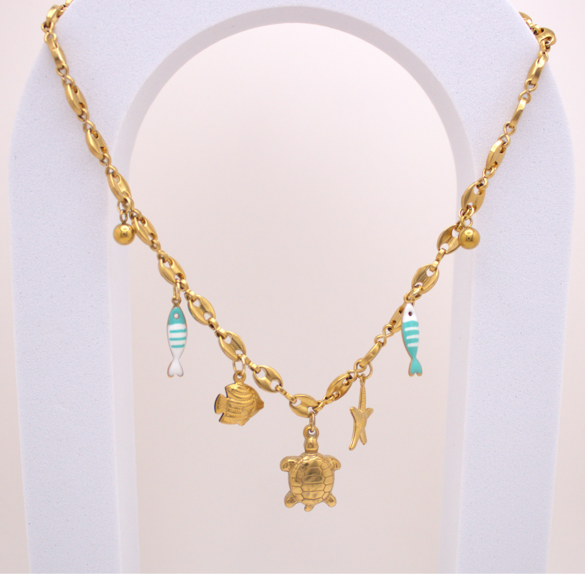 Ocean Breeze Necklace in gold with turtle, starfish, and turquoise fish charms
