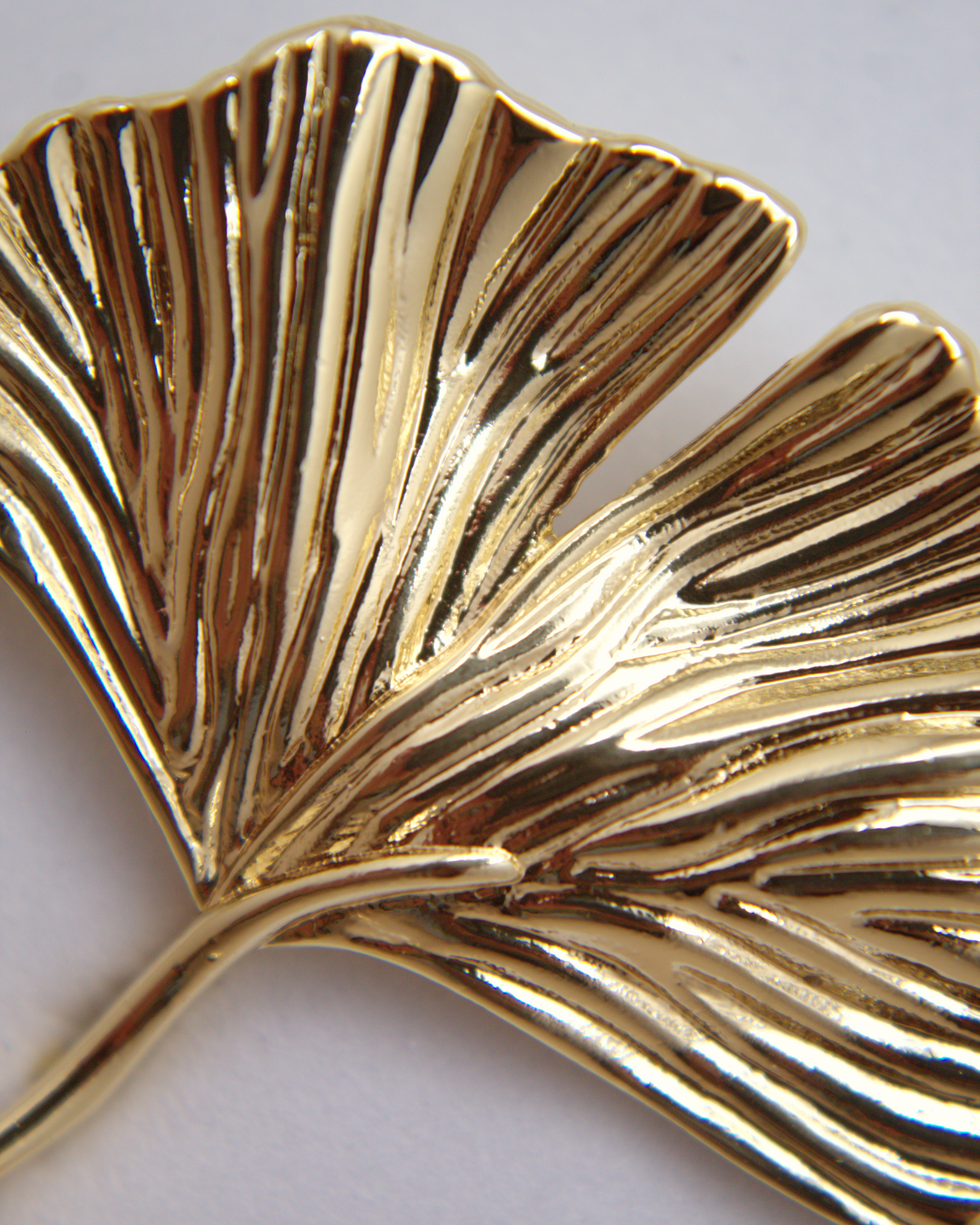 Statement gold earrings with soft, natural leaf-like shape.