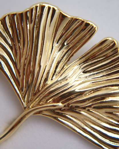 Statement gold earrings with soft, natural leaf-like shape.