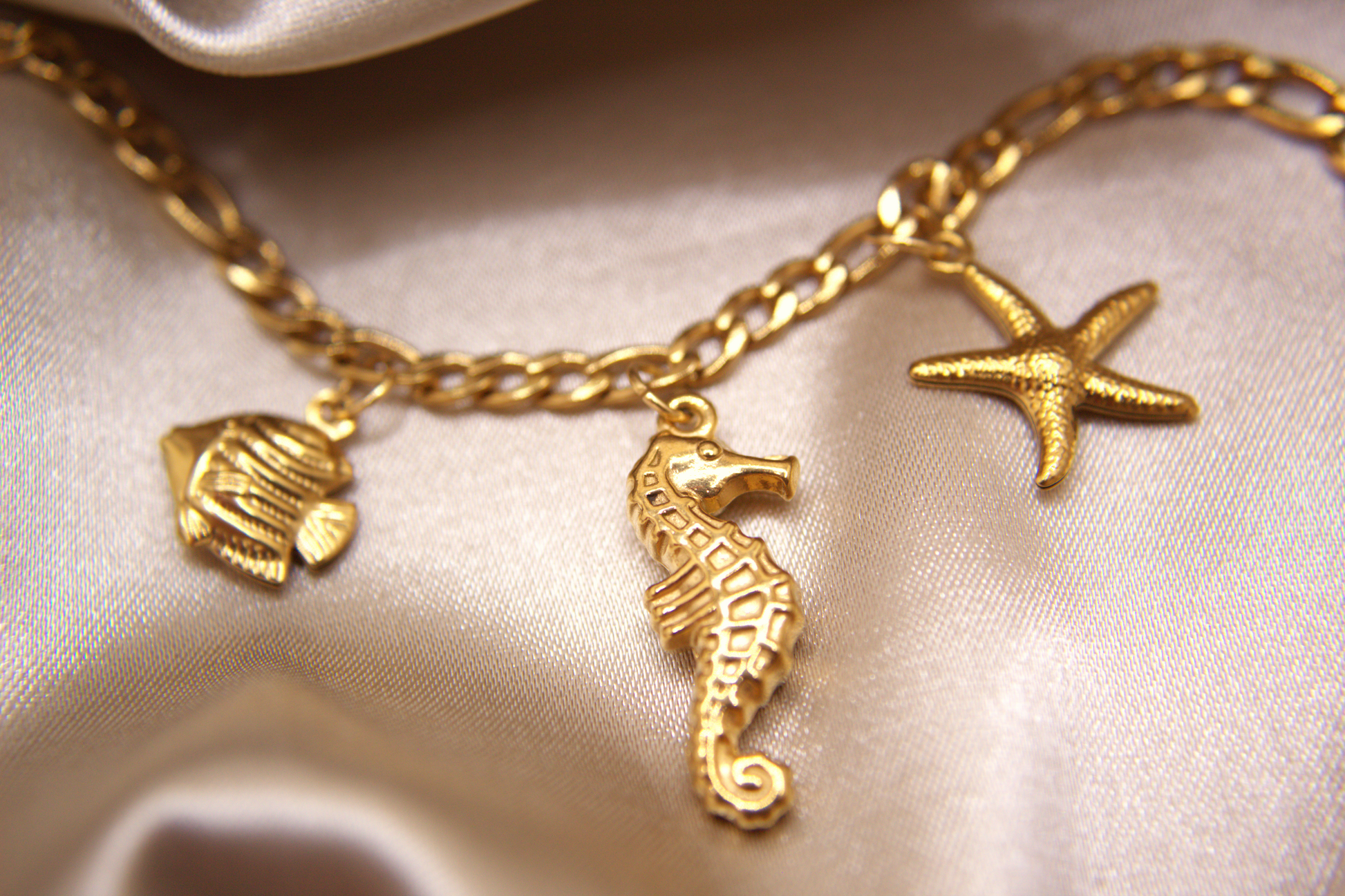 Gold bracelet with seahorse, fish, and starfish charms by Selva Accessories