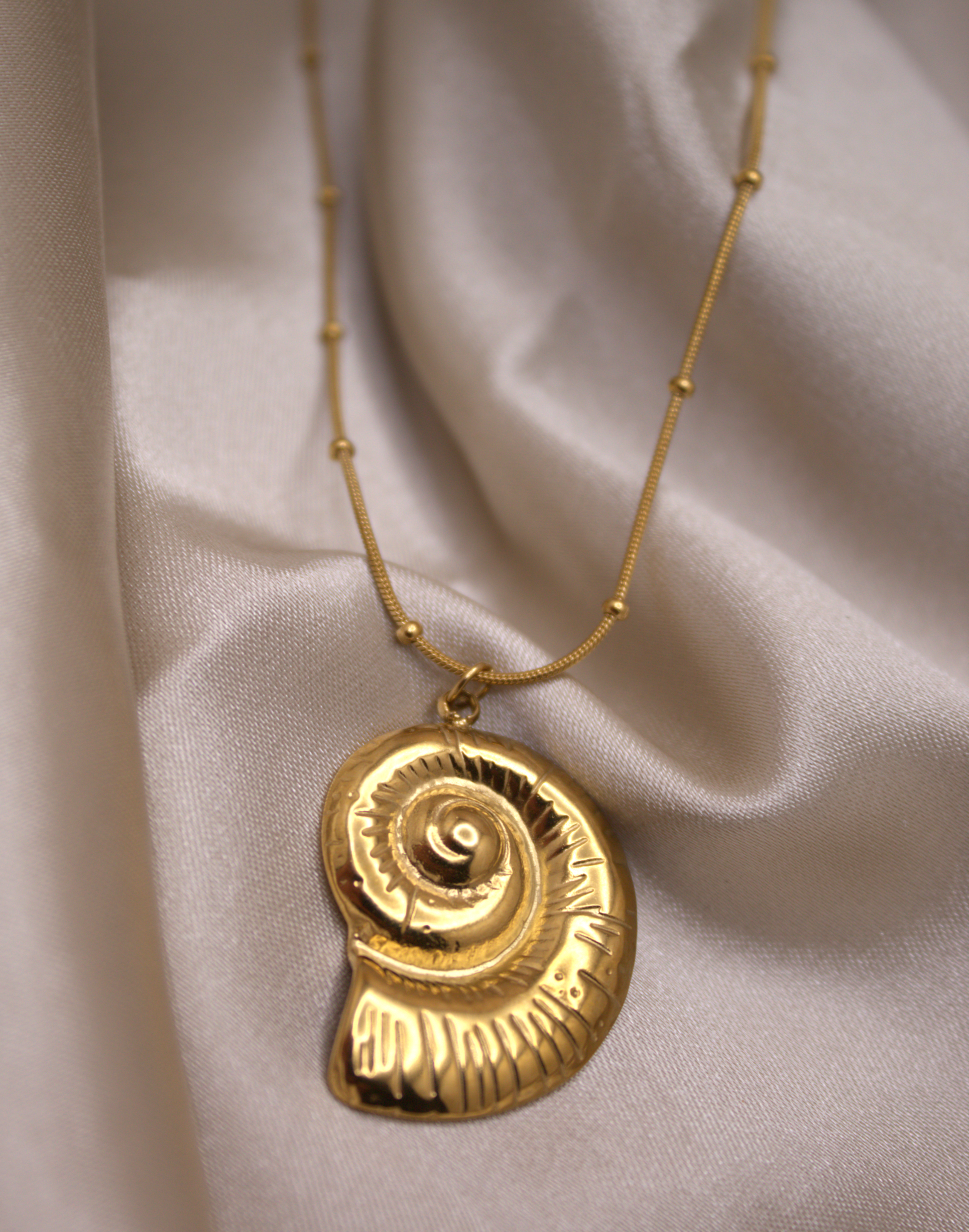 Gold stainless steel necklace featuring seashell pendant by Selva Accessories