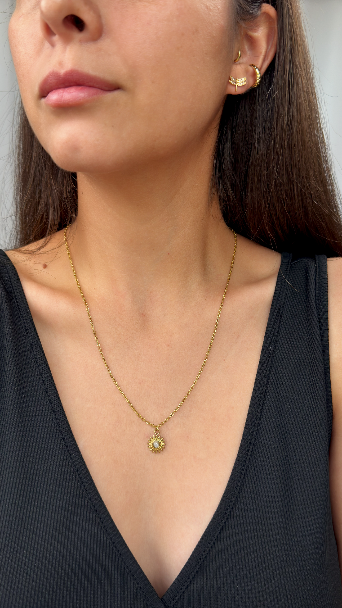 Gold PVD stainless steel sun necklace, delicate pendant with white gemstone accent.